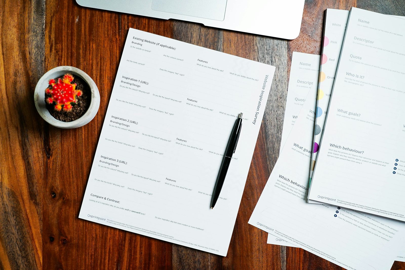 Documents et stylo posés sur une table en bois, comme l'acte et le contrat santé à relire avant de fixer le périmètre familial