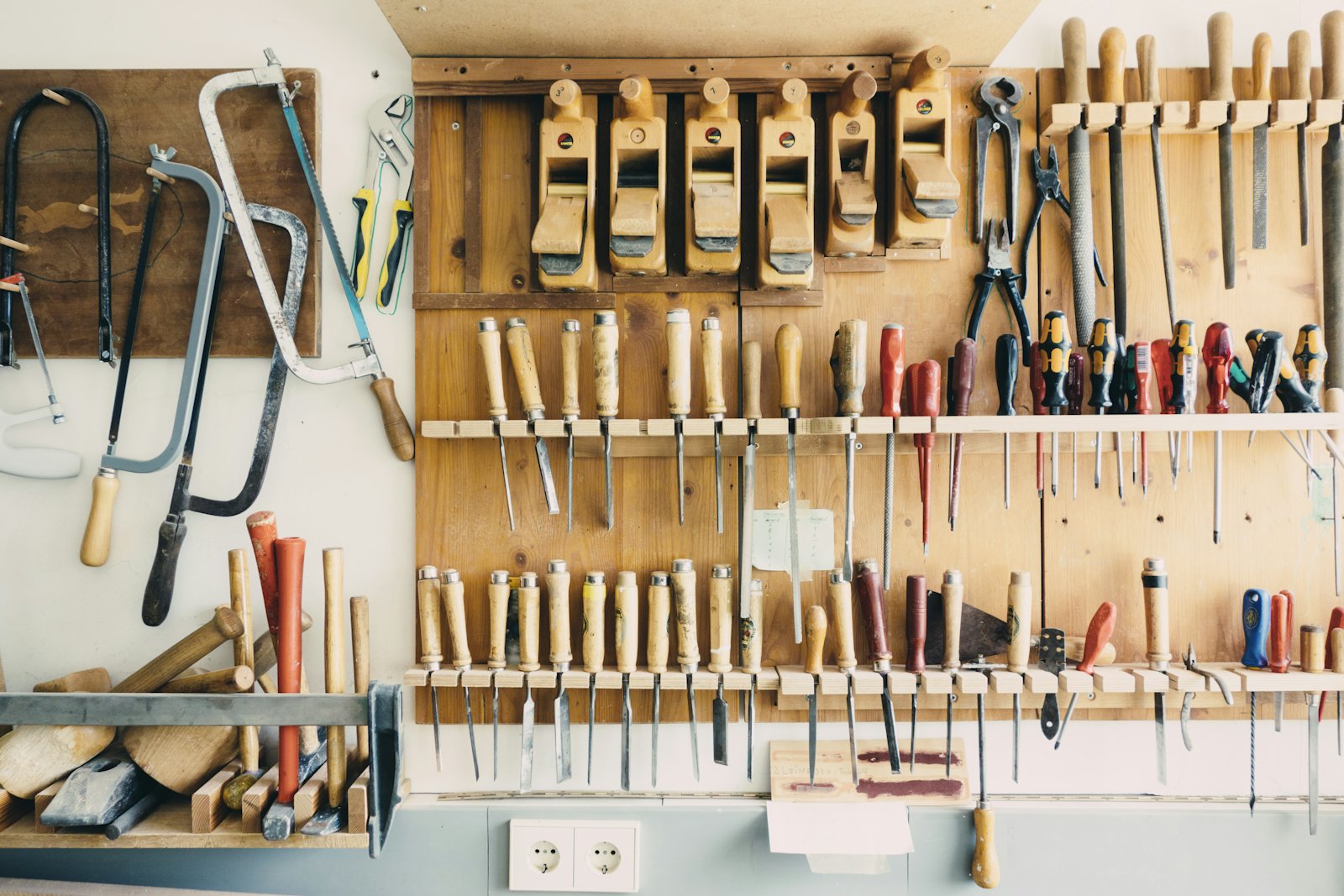 Panneau d'atelier de menuiserie avec outils manuels rangés sur des râteliers de bois