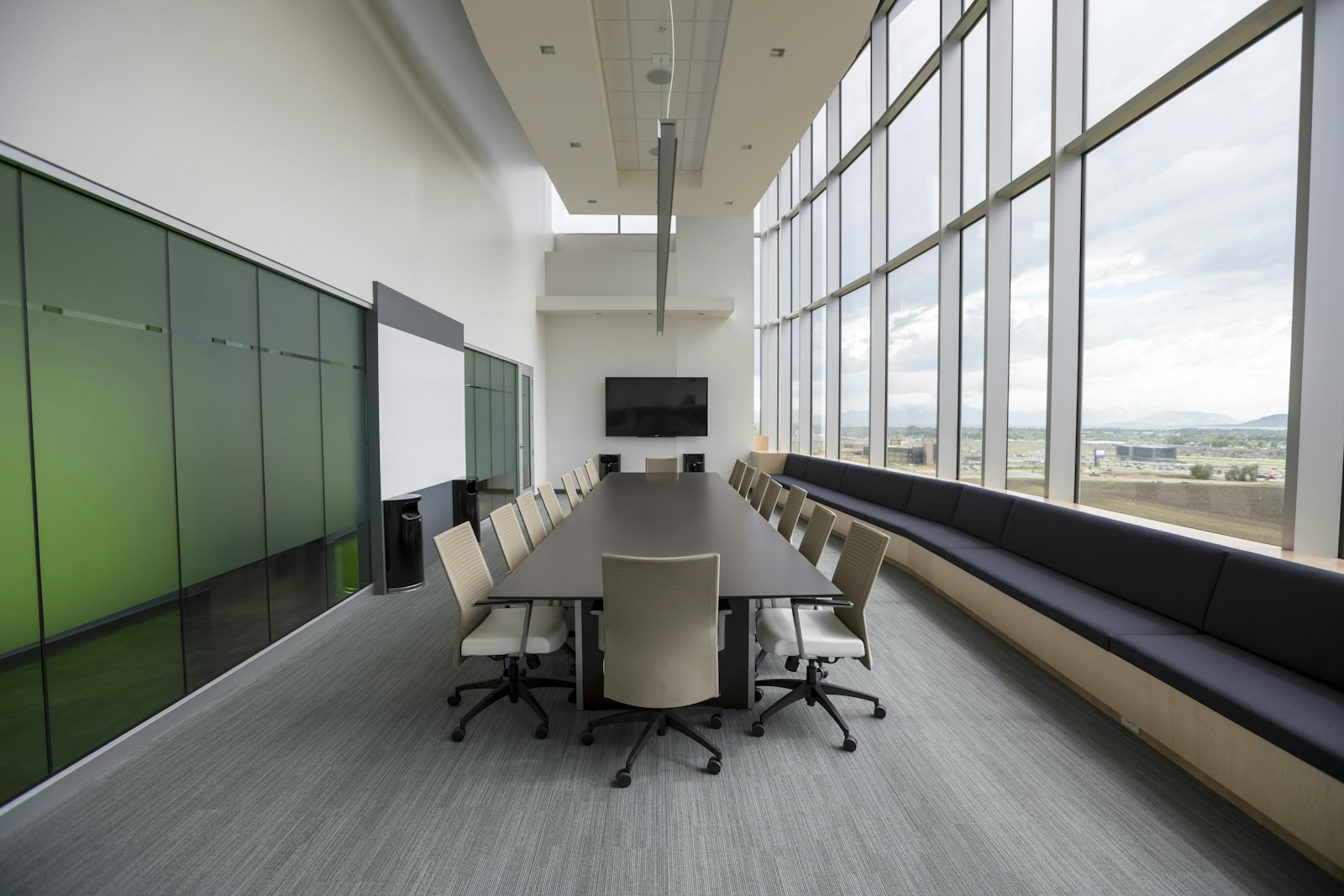 Table de réunion en bois entourée de chaises vides dans une salle de conseil