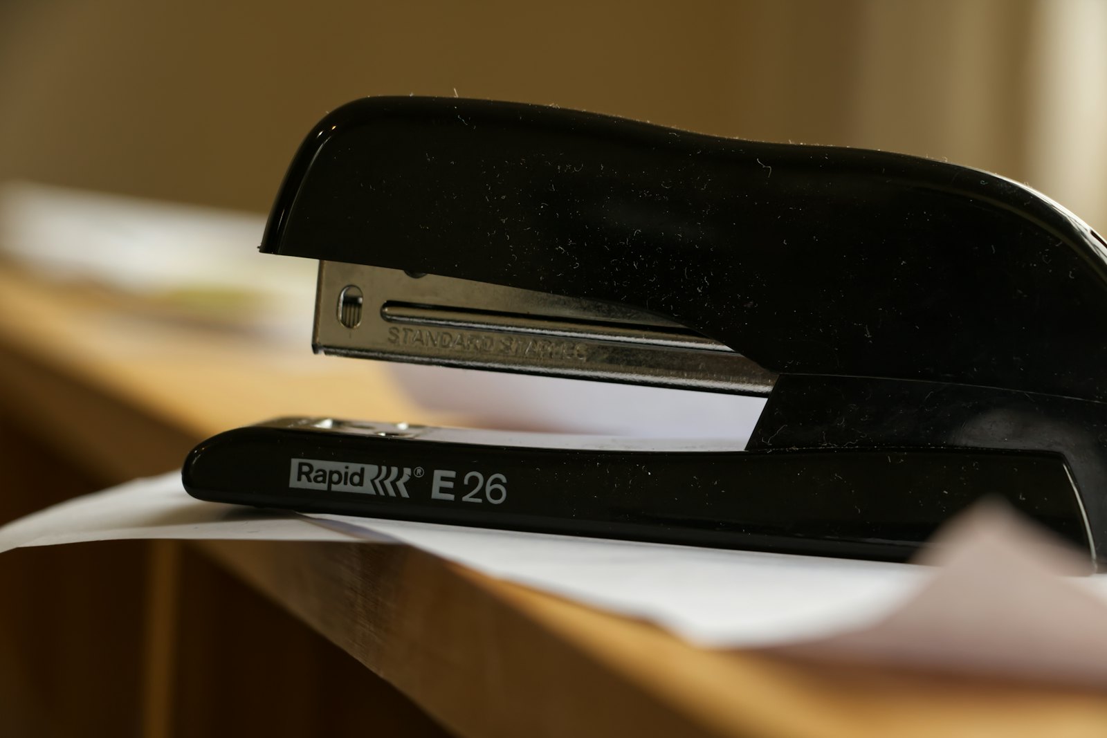 Une agrafeuse noire posée sur des documents empilés au coin d'un bureau