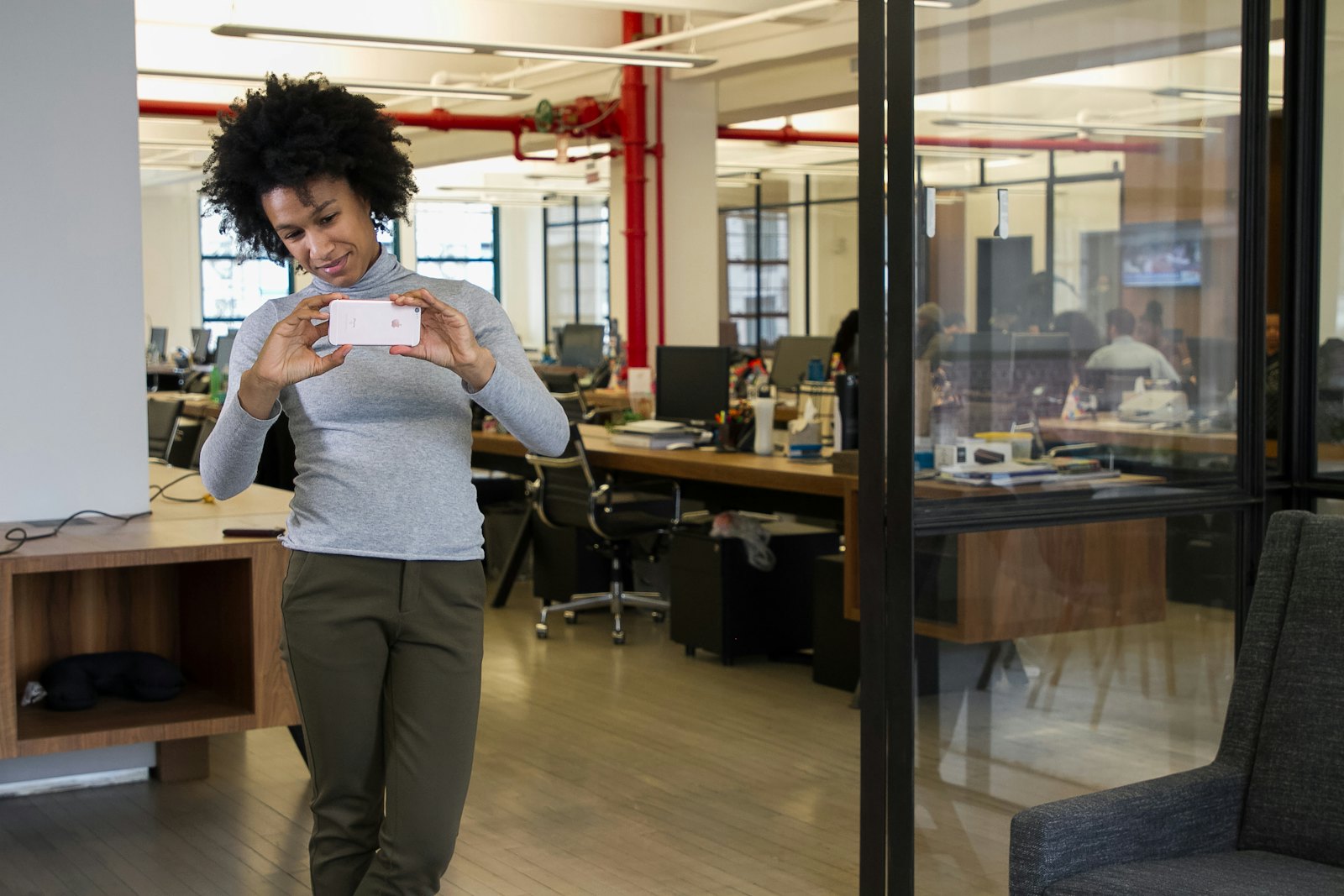 Une collaboratrice traverse les bureaux avec un carton, le jour de son départ de l'entreprise