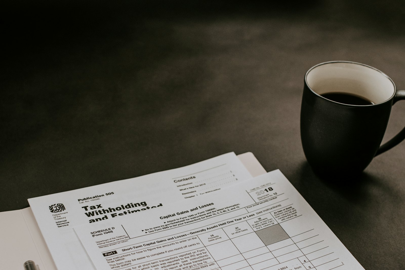 Bureau avec calculatrice, stylo et documents de paie servant à rapprocher les indemnités journalières et le salaire maintenu