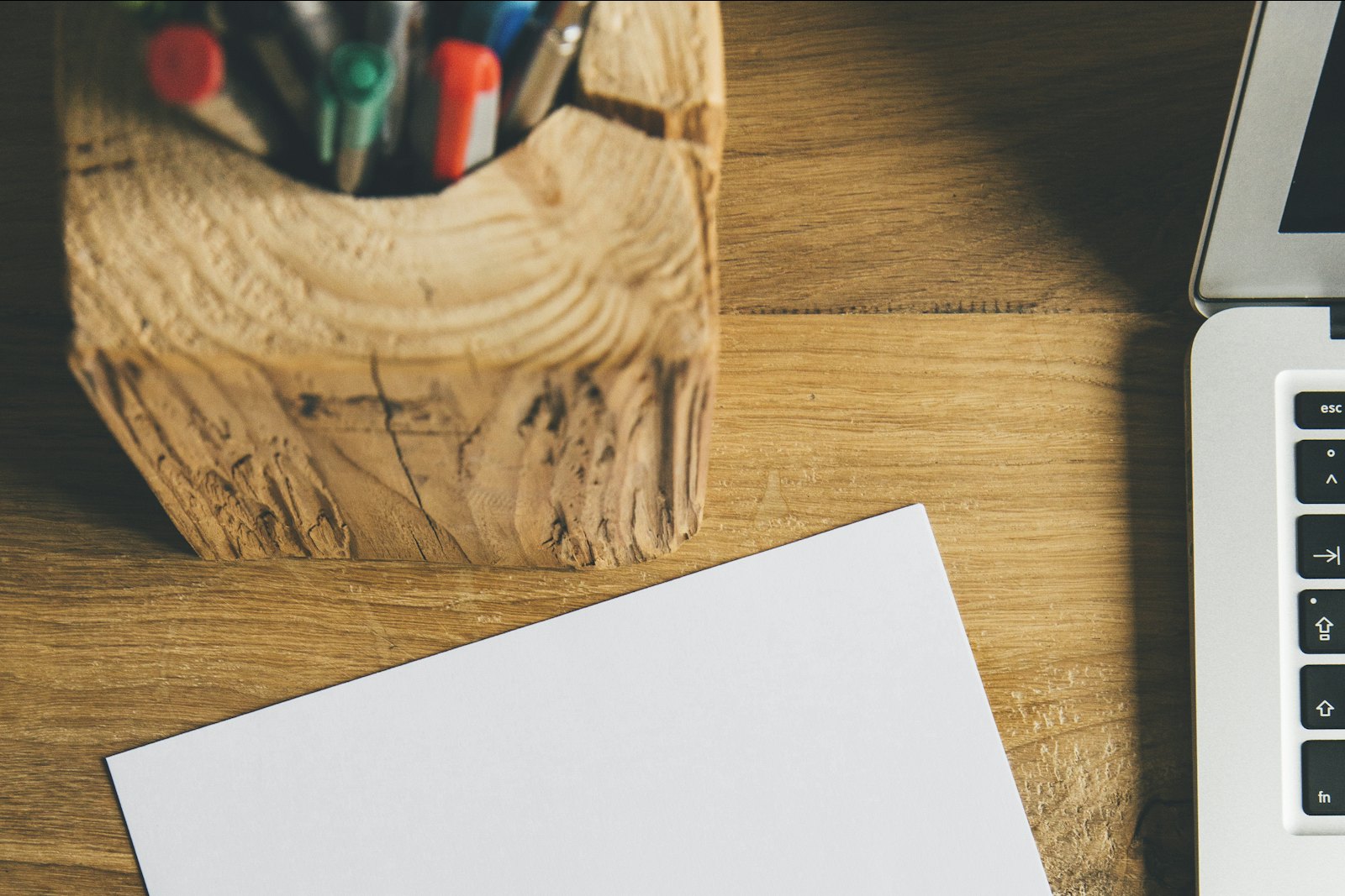 Feuille de papier vierge et stylo noir posés sur un bureau clair