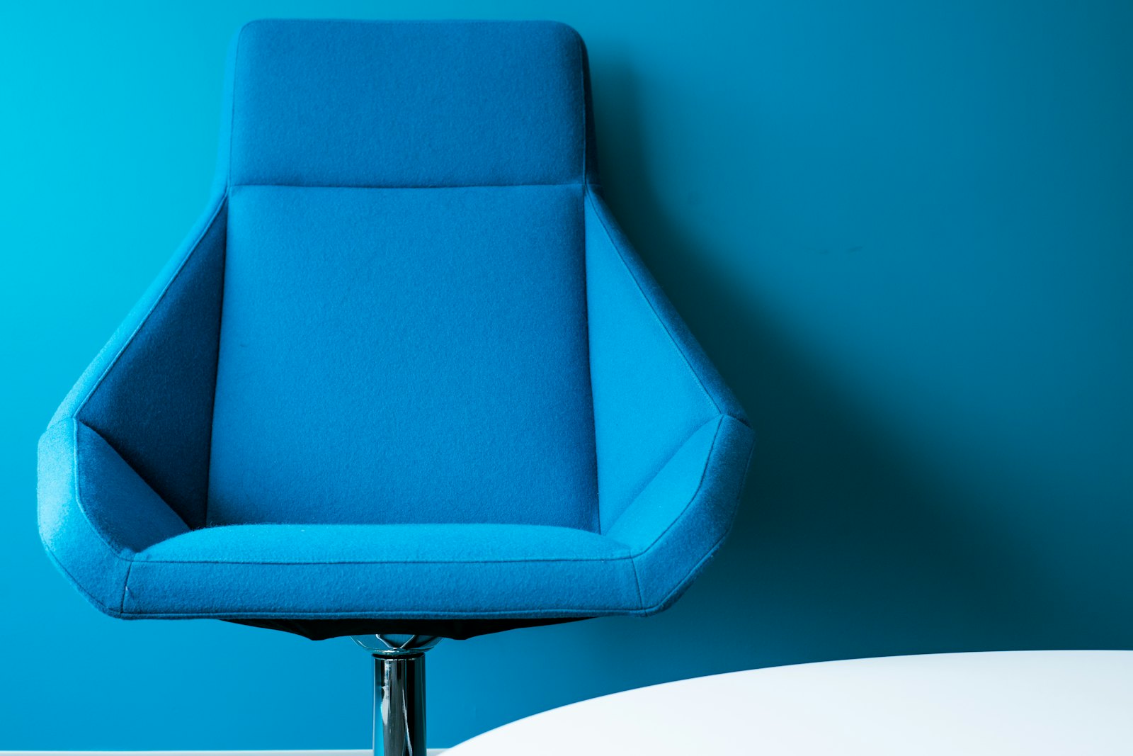Fauteuil de bureau vide devant une table blanche, poste momentanément inoccupé