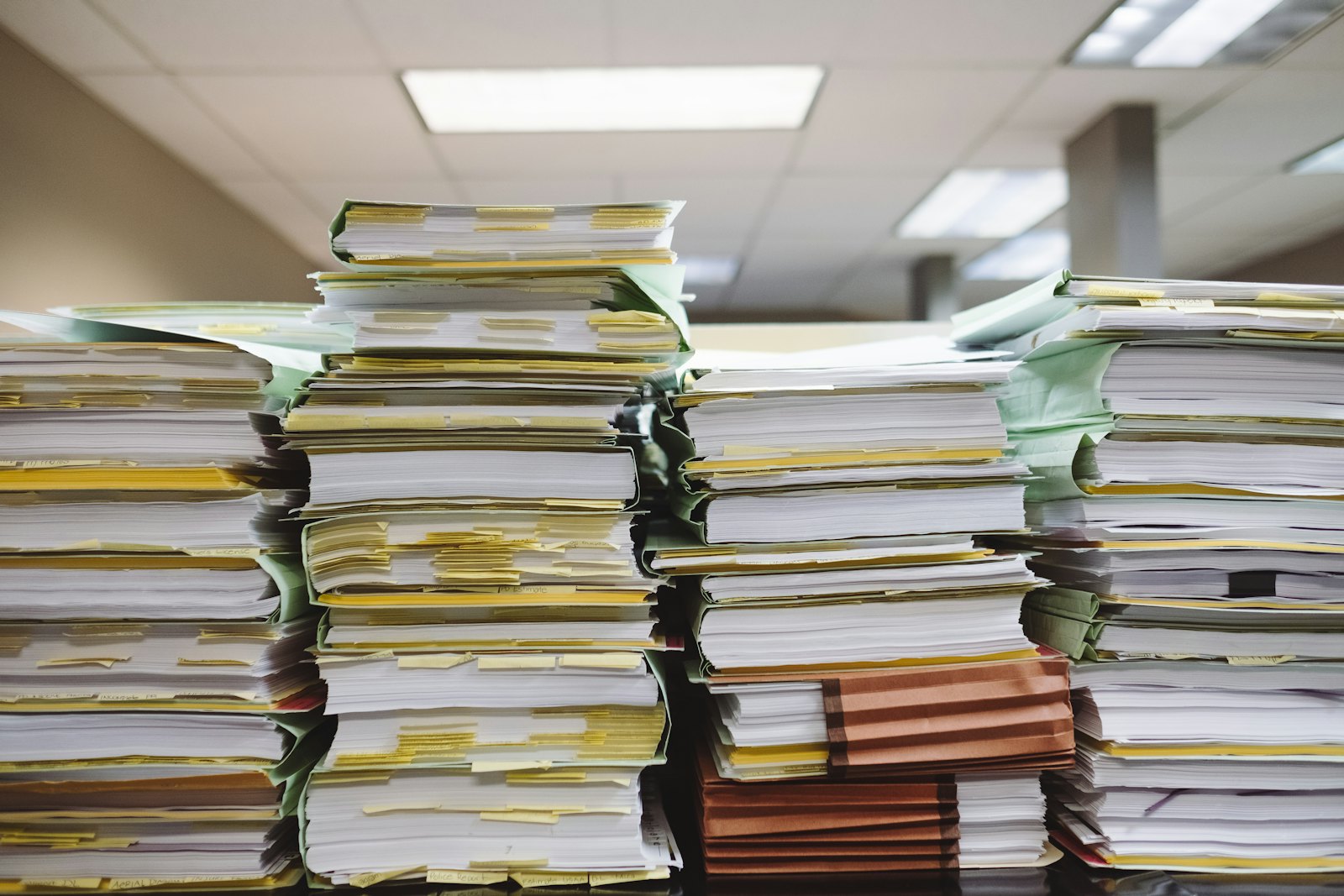 Dossiers et documents empilés sur un bureau, comme l'accord de branche à relire avant de choisir son organisme assureur