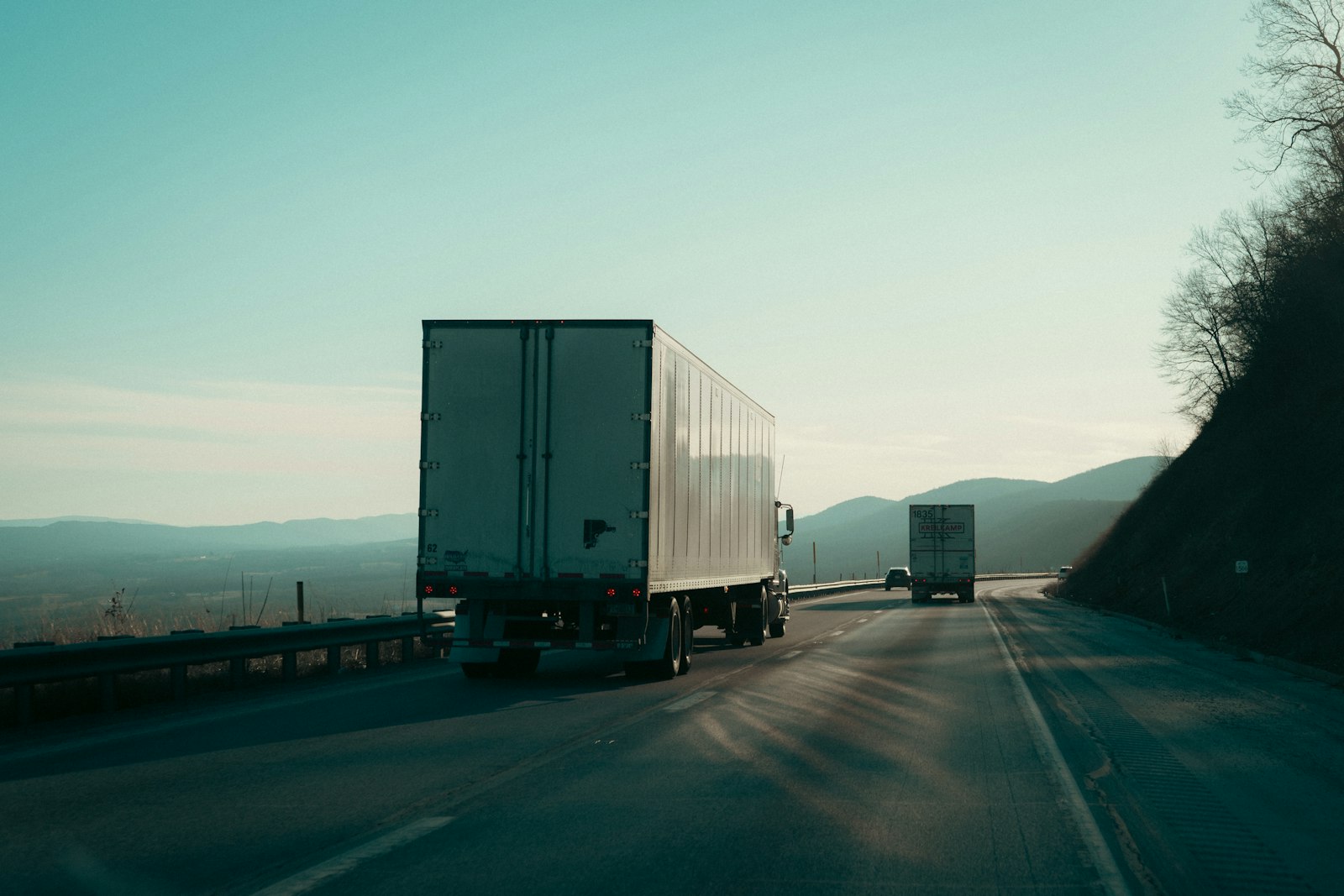 Deux poids lourds sur une autoroute, illustration des entreprises de transport routier de marchandises soumises au régime santé et prévoyance de la branche