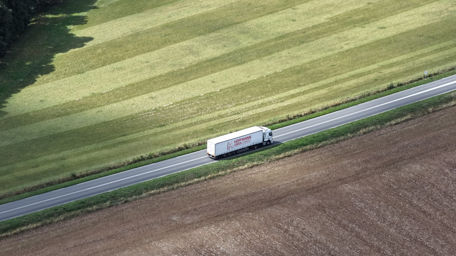 Camion blanc sur une route de campagne, image des conducteurs routiers dont la couverture santé, prévoyance et inaptitude à la conduite est fixée par la convention collective